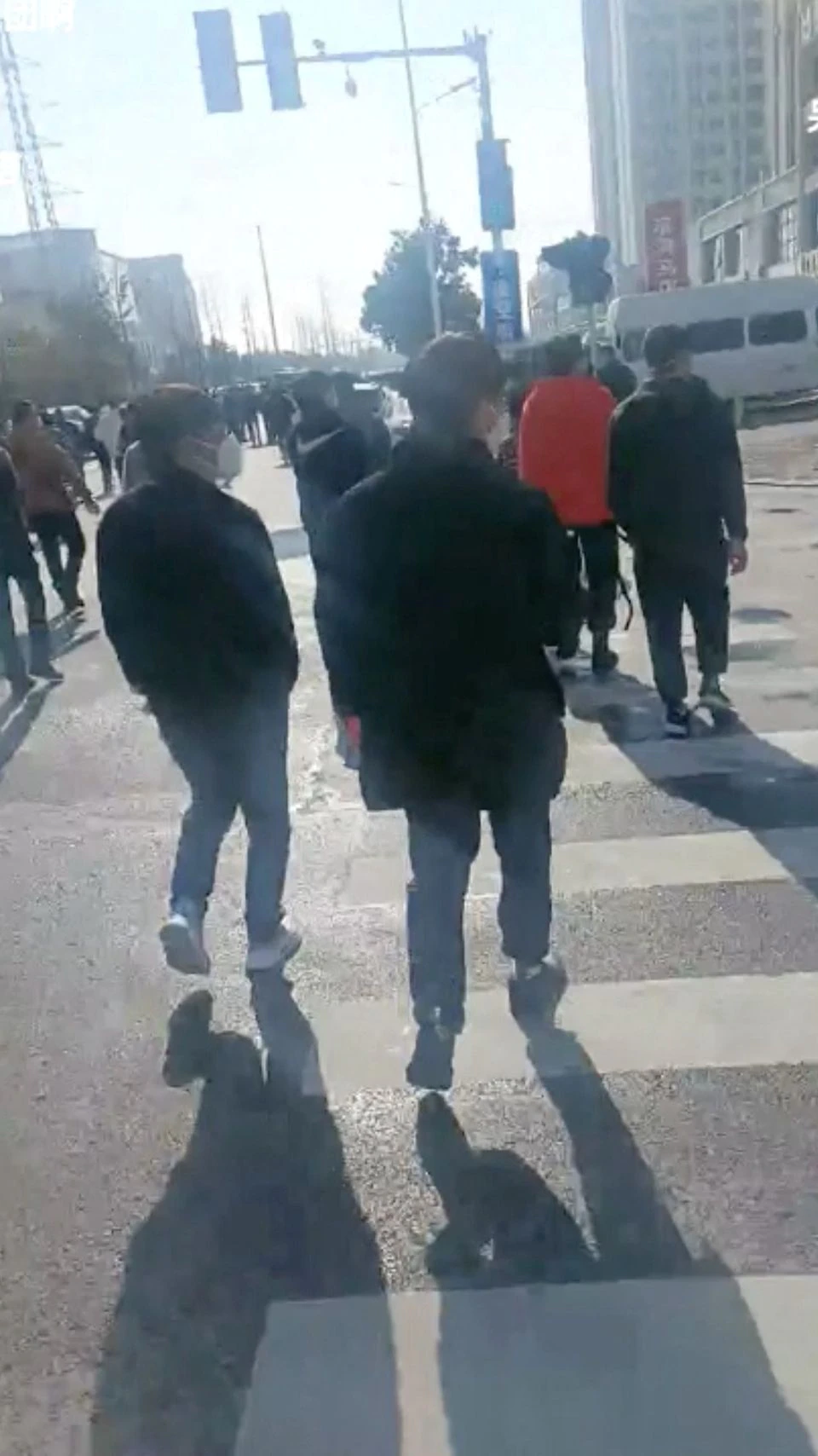 Group of people seem to walk towards the Foxconn factory following a protest at their plant in Zhengzhouu, China in this screen grab obtained from a video released November 23, 2022. Video obtained by Reuters