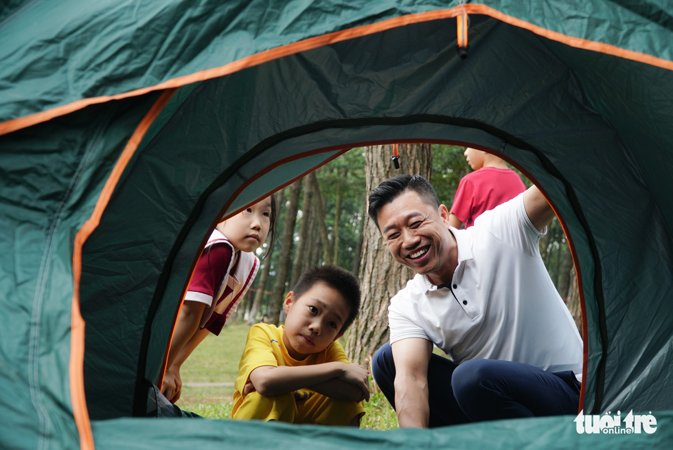 Nguyen Viet Hai plays with his kids while camping in Ba Vi pine forest, Hanoi, Vietnam. Photo: Nguyen Hien / Tuoi Tre News