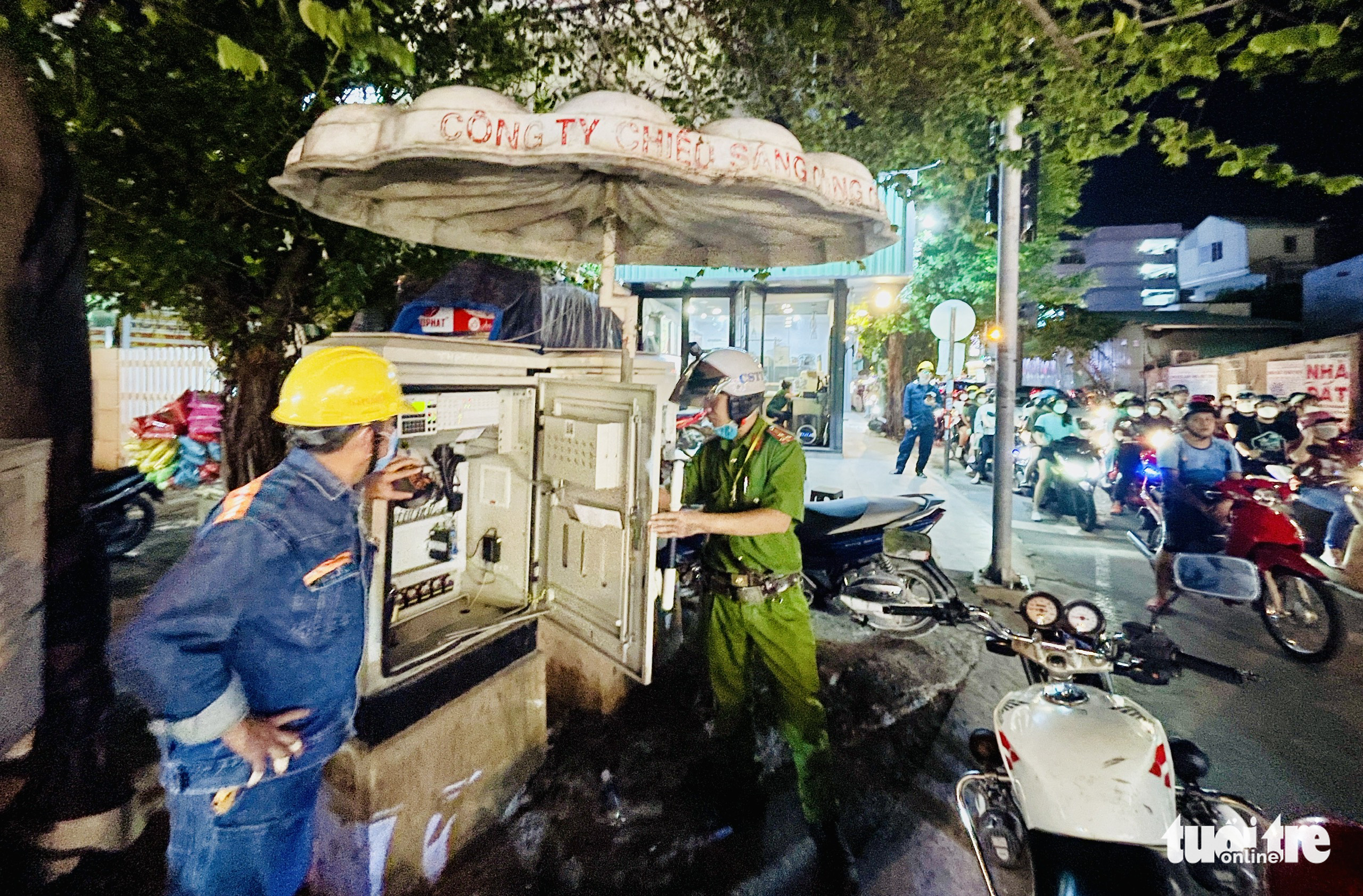 A traffic police officer and an electrical engineer handle a faulty traffic light at the intersection of Ung Van Khiem Street and Nguyen Gia Tri Street in Binh Thanh District, Ho Chi Minh City, November 25, 2022. Photo: Chau Tuan / Tuoi Tre