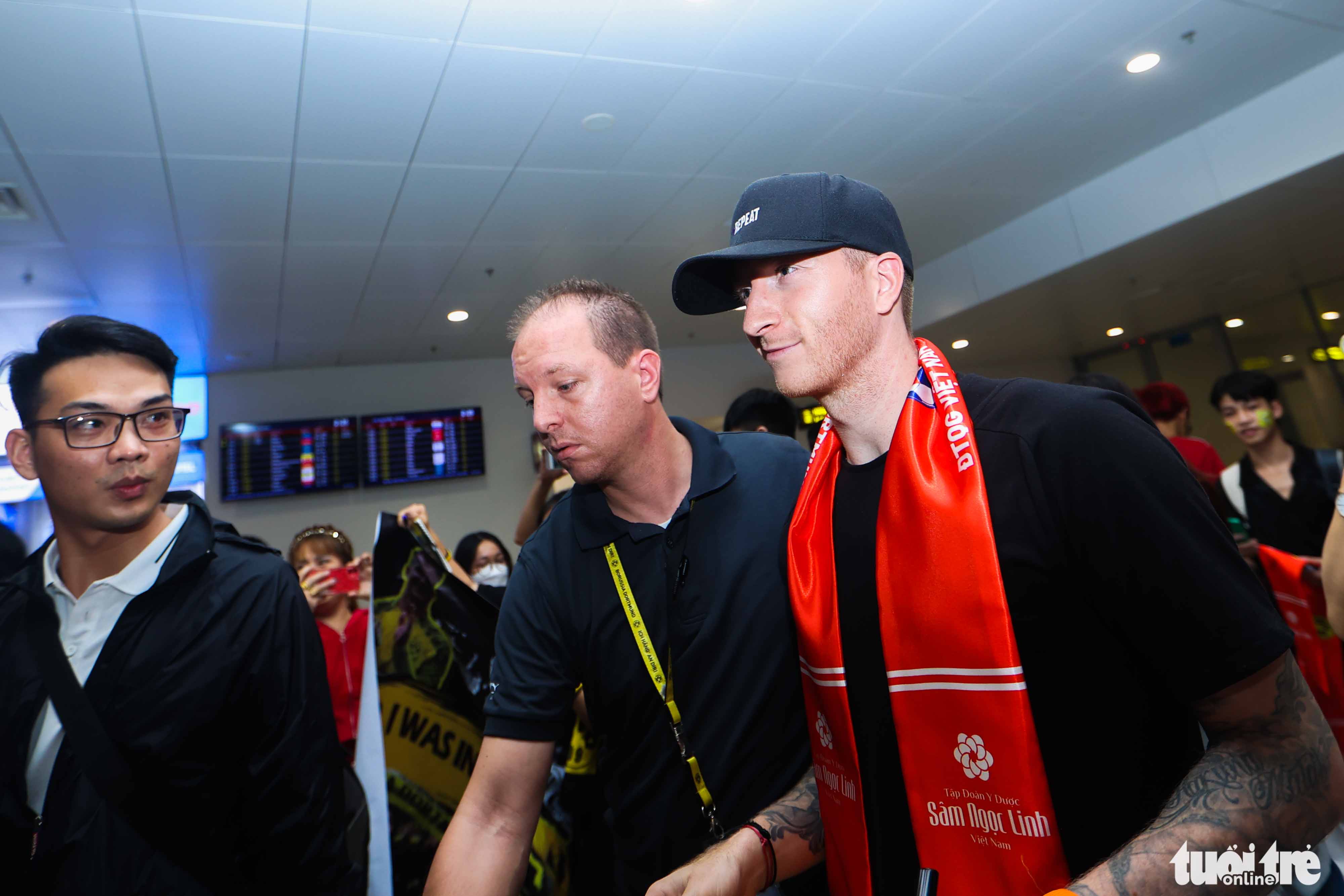 Borussia Dortmund’s Marco Reus (R) arrives at Noi Bai International Airport in Hanoi, November 29, 2022. Photo: Nguyen Khanh / Tuoi Tre