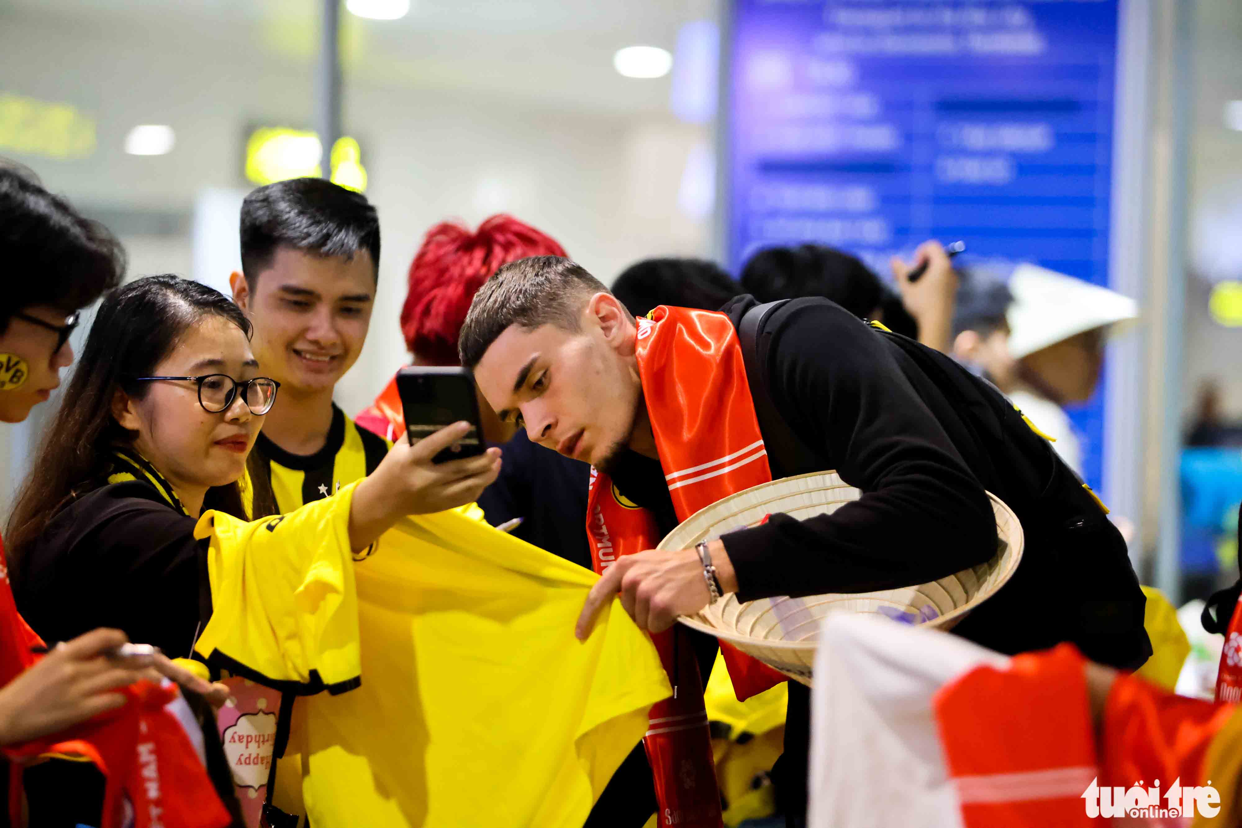 Borussia Dortmund's Moritz Broschinski signs for fans at Noi Bai International Airport in Hanoi, November 29, 2022. Photo: Nguyen Khanh / Tuoi Tre