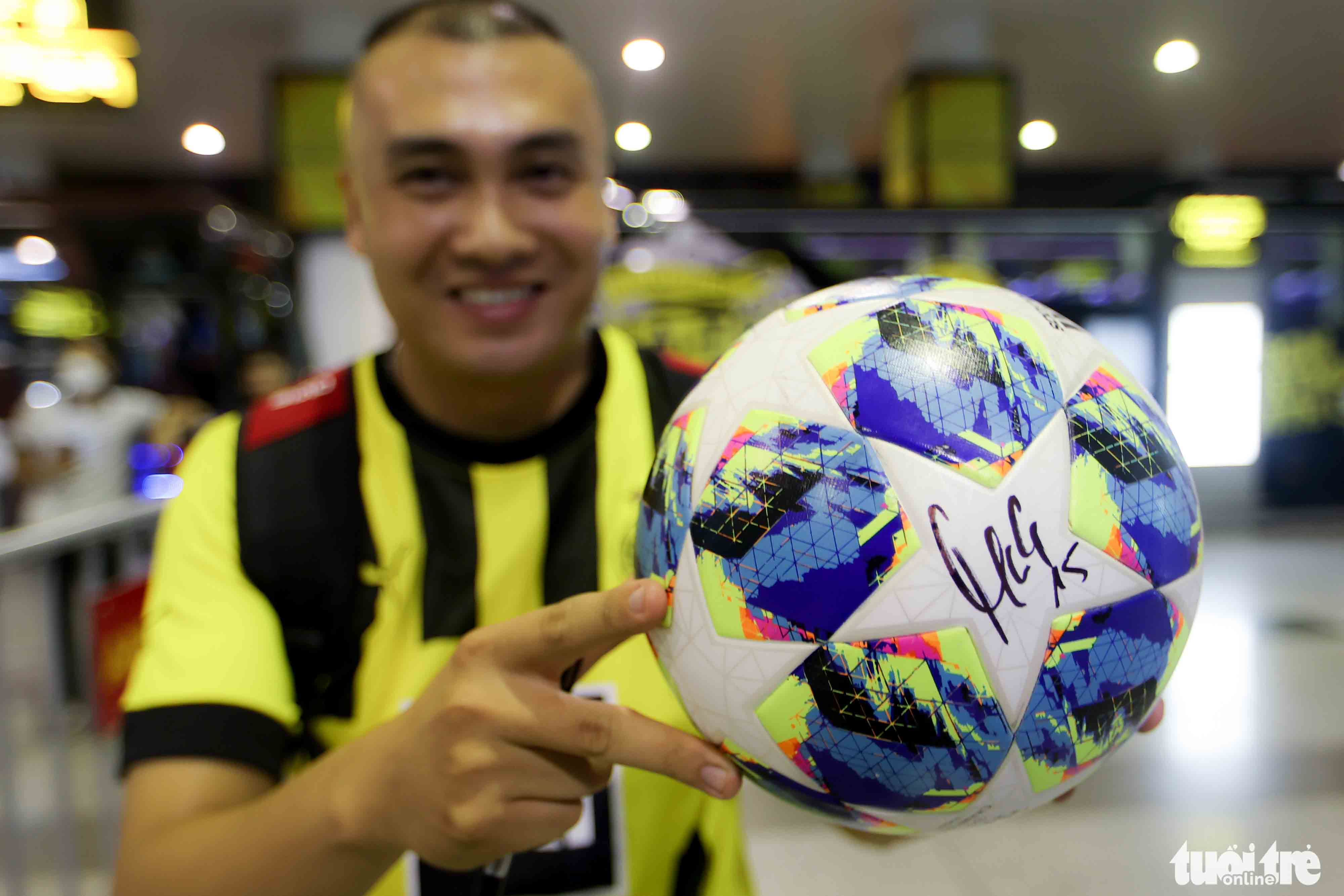 A fan shows a ball signed by Borussia Dortmund’s Mats Hummels at Noi Bai International Airport in Hanoi, November 29, 2022. Photo: Nguyen Khanh / Tuoi Tre