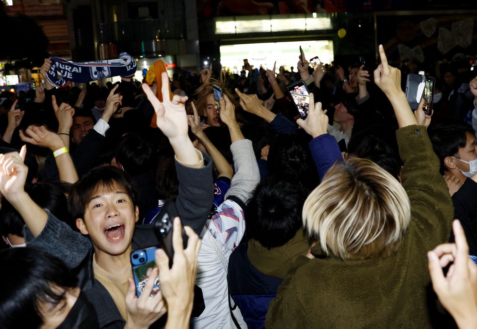 Soccer Football - FIFA World Cup Qatar 2022 - Fans in Tokyo watch Japan v Spain - Tokyo, Japan - December 2, 2022 Japan fans celebrate at the Shibuya Crossing after the match as Japan qualify for the knockout stages. Photo: Reuters