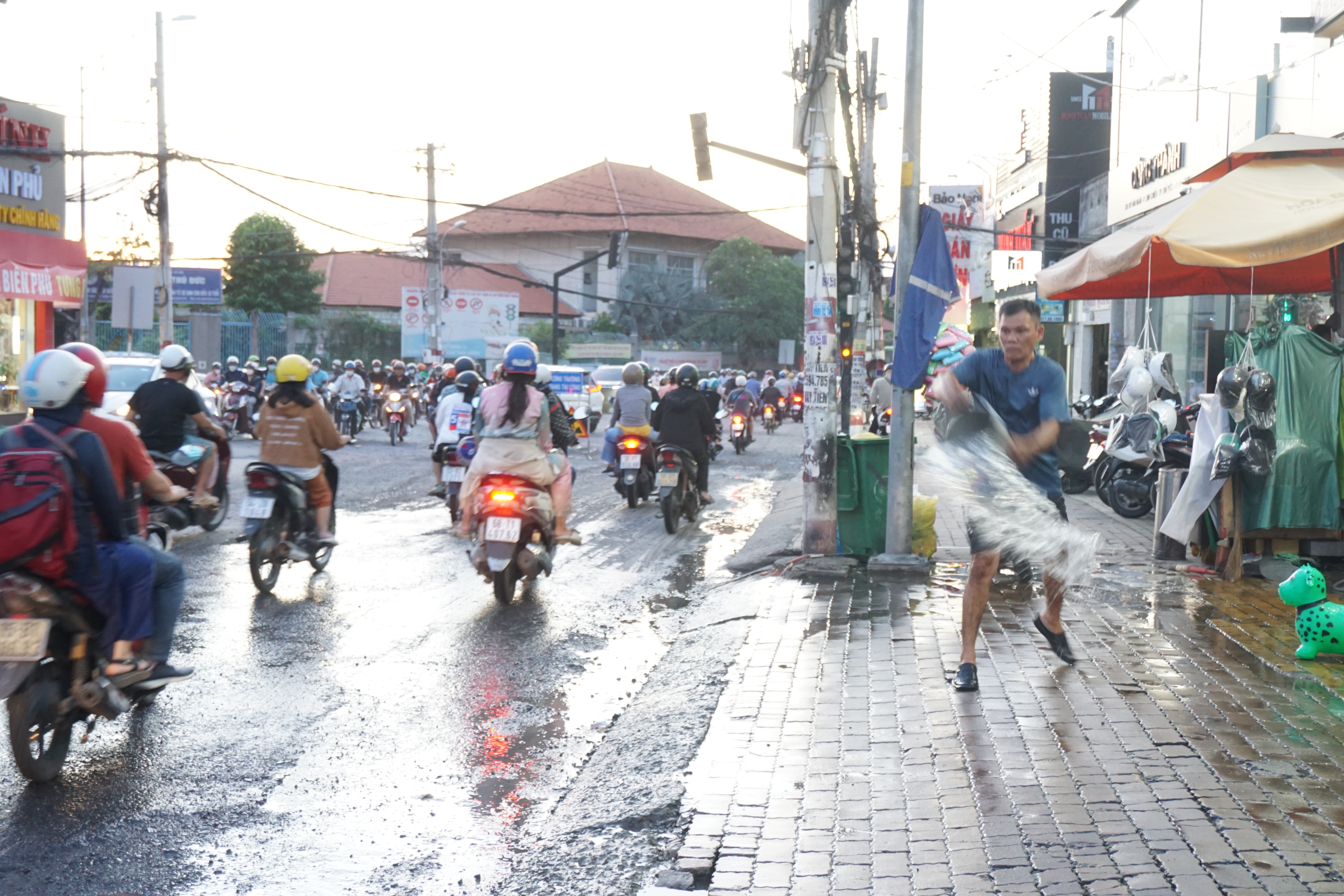 A man sprays water to stop dust from collecting on Vo Van Ngan Street in Thu Duc City, Ho Chi Minh City. Photo: Duc Phu / Tuoi Tre