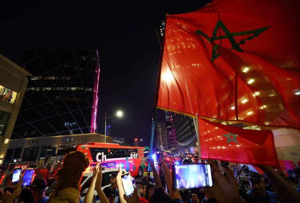 Soccer Football - FIFA World Cup Qatar 2022 - Morocco team bus arrives at the hotel - Wyndham Doha West Bay Hotel, Doha, Qatar - December 6, 2022 Morocco fans take photos of the team bus as it arrives as they celebrate progressing to the quarter finals after beating Spain. Photo: Reuters