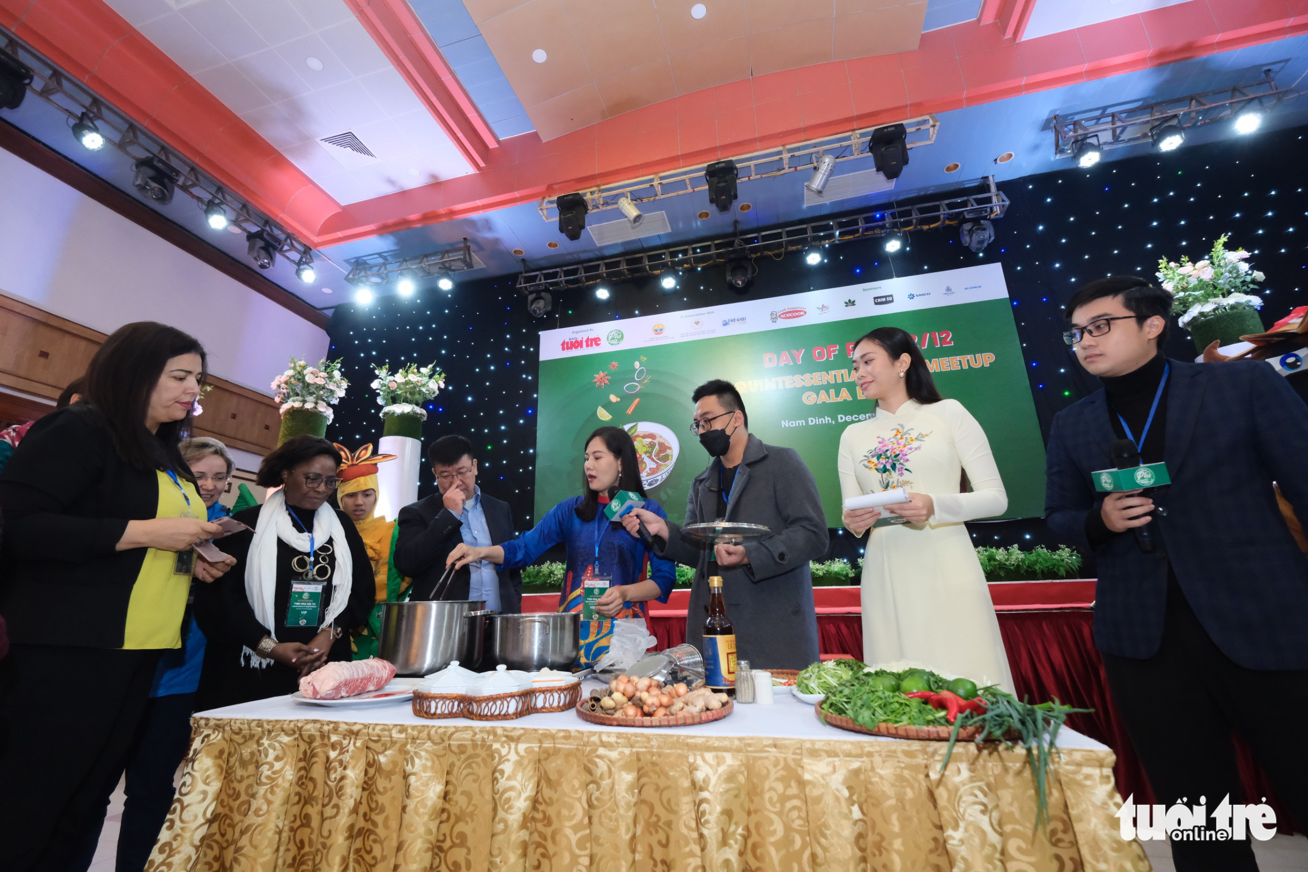 Delegates listen to UNESCO culinary artisan Hoang Minh Hien (R, 4th)'s guide on how to cook pho at the Day of Pho event organized by Tuoi Tre (Youth) newspaper in Nam Dinh Province, Vietnam, December 10, 2022. Photo: Nam Tran / Tuoi Tre