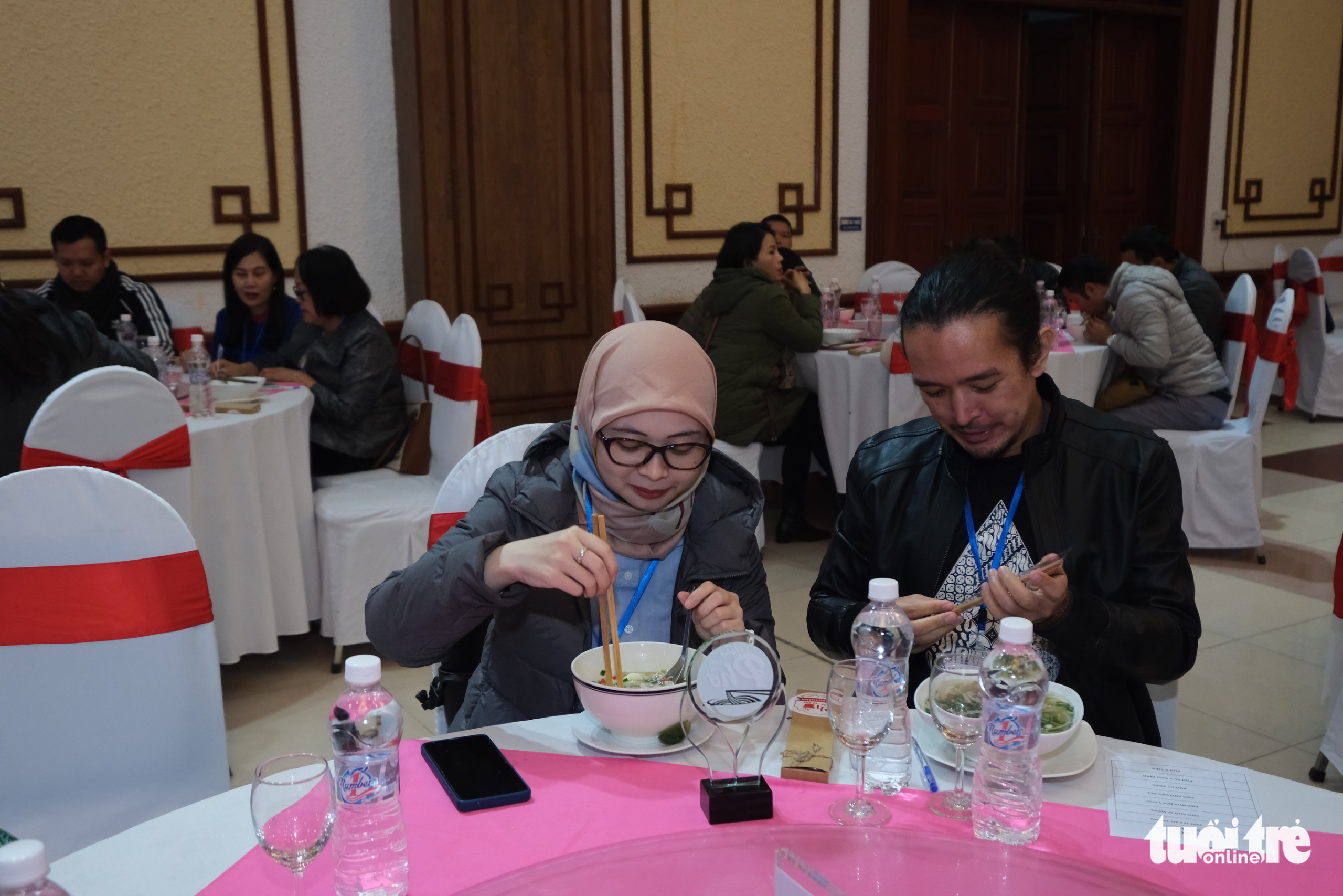 Yully Yudhantari Saputri (L), second secretary of the Embassy of Indonesia in Vietnam, and her husband experience pho at the Day of Pho event organized by Tuoi Tre (Youth) newspaper in Nam Dinh Province, Vietnam, December 10, 2022. Photo: Nam Tran / Tuoi Tre