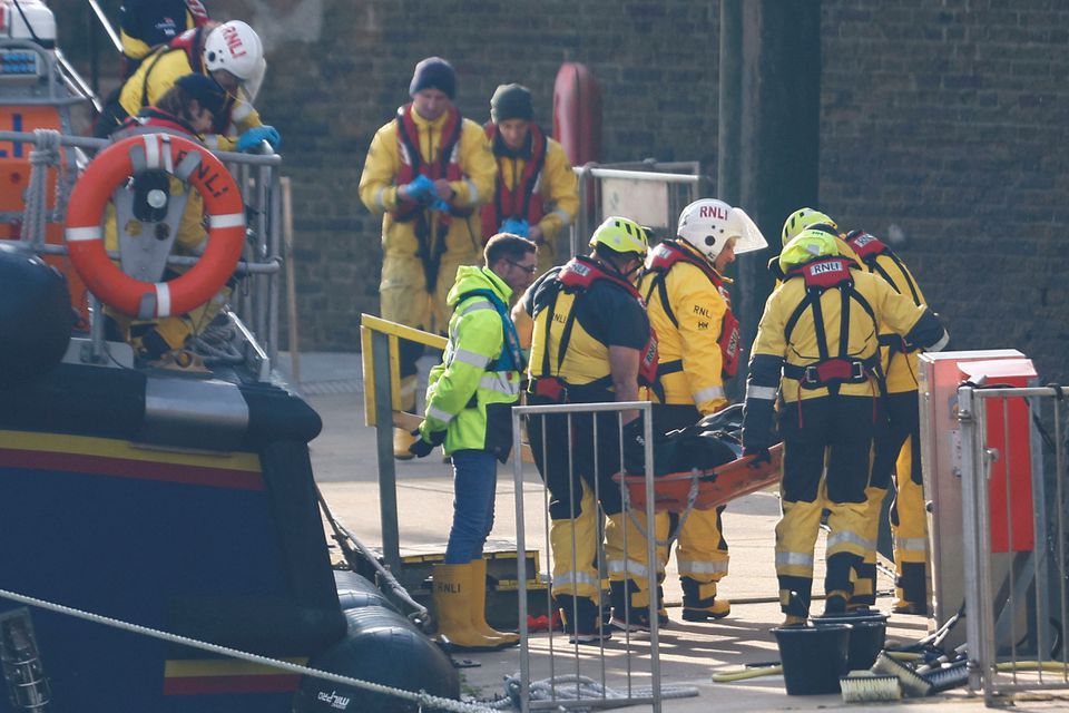 Rescue workers carry a body bag on a stretcher, as they return to the Port of Dover amid a rescue operation of a missing migrant boat, in Dover, Britain December 14, 2022. Photo: Reuters