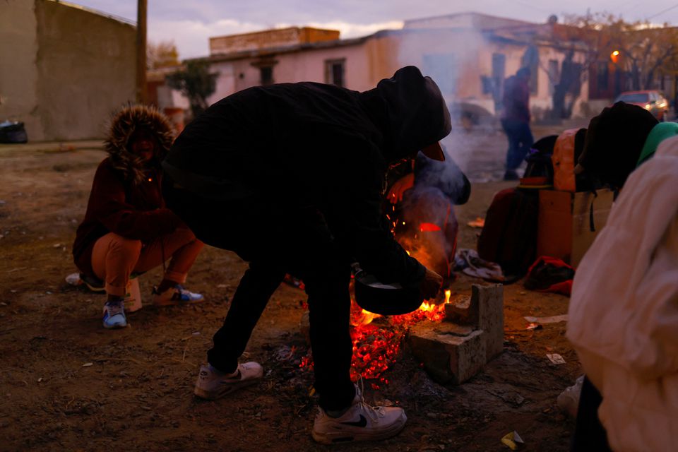 Venezuelan migrants prepare food over a campfire near the border between Mexico and the U.S., as they wait for the announcement about the end of Title 42 on December 21, in Ciudad Juarez, Mexico December 18, 2022. Photo: Reuters