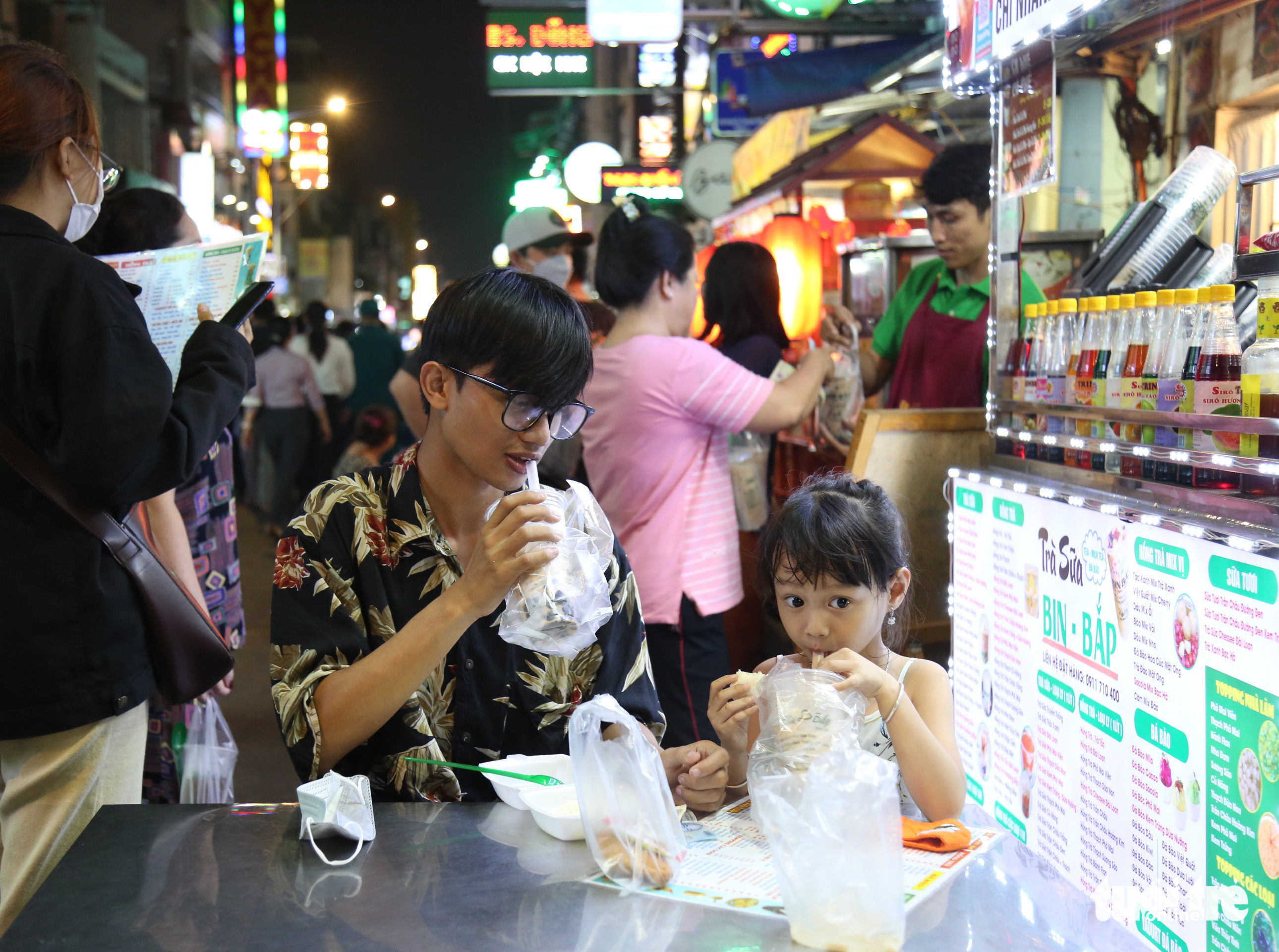 Thuan Khanh (L) and Thuan An enjoy beverages at Nguyen Thuong Hien Food Street in District 3, Ho Chi Minh City, December 21, 2022. Photo: Phuong Quyen / Tuoi Tre