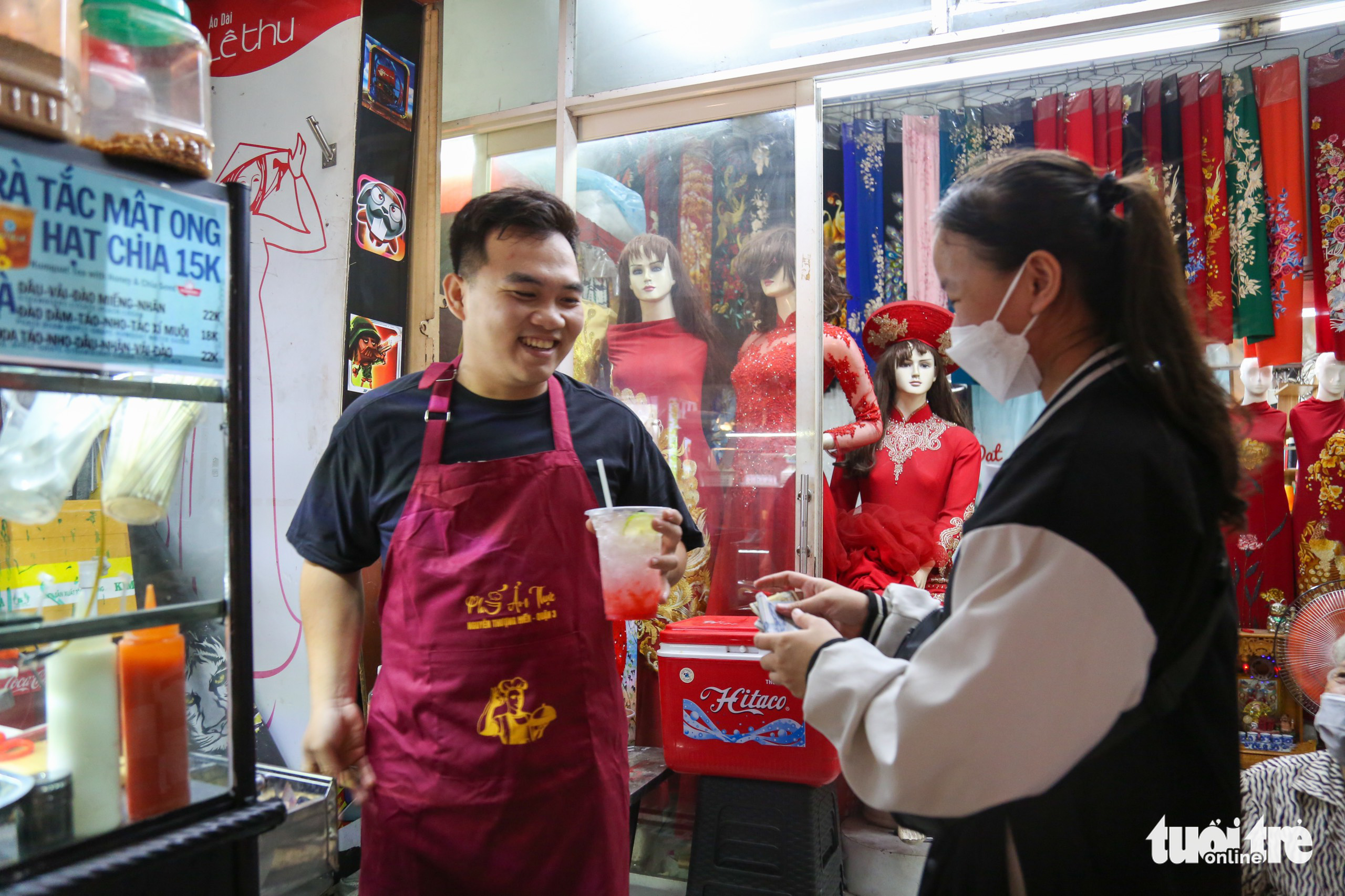 Nam (L) sells a beverage to a customer at Nguyen Thuong Hien Food Street in District 3, Ho Chi Minh City, December 21, 2022. Photo: Phuong Quyen / Tuoi Tre