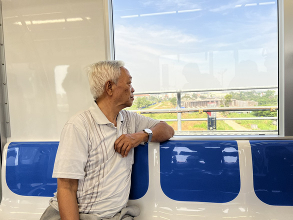 86-year-old Le Van Ninh, a resident of Ho Chi Minh City, looks through a window on a metro train during a test run on December 21, 2022. Photo: Xuan Doan / Tuoi Tre