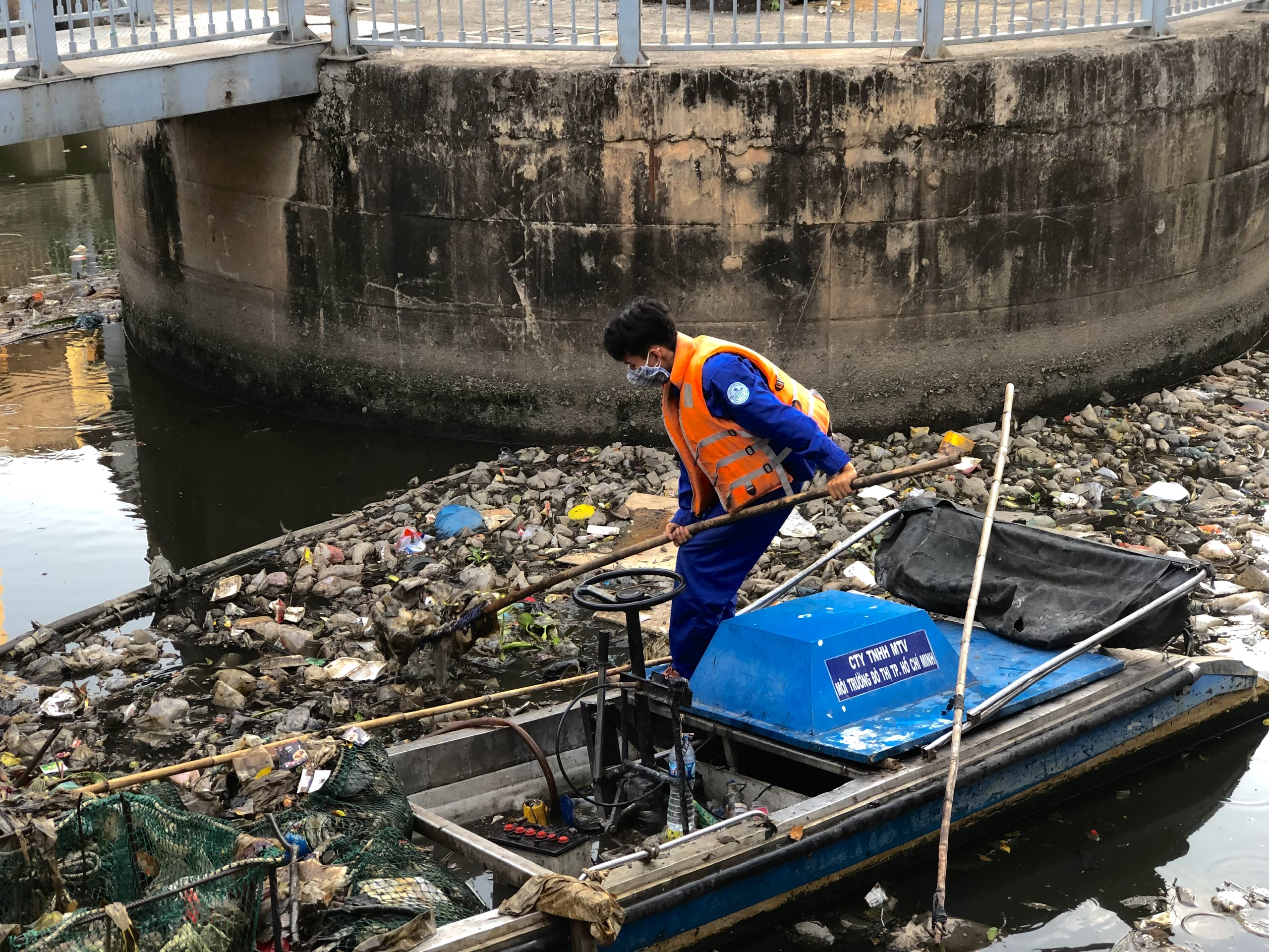 A sanitation worker removes garbage from Nhieu Loc-Thi Nghe Canal in Ho Chi Minh City, December 2022. Photo: Luu Duyen / Tuoi Tre