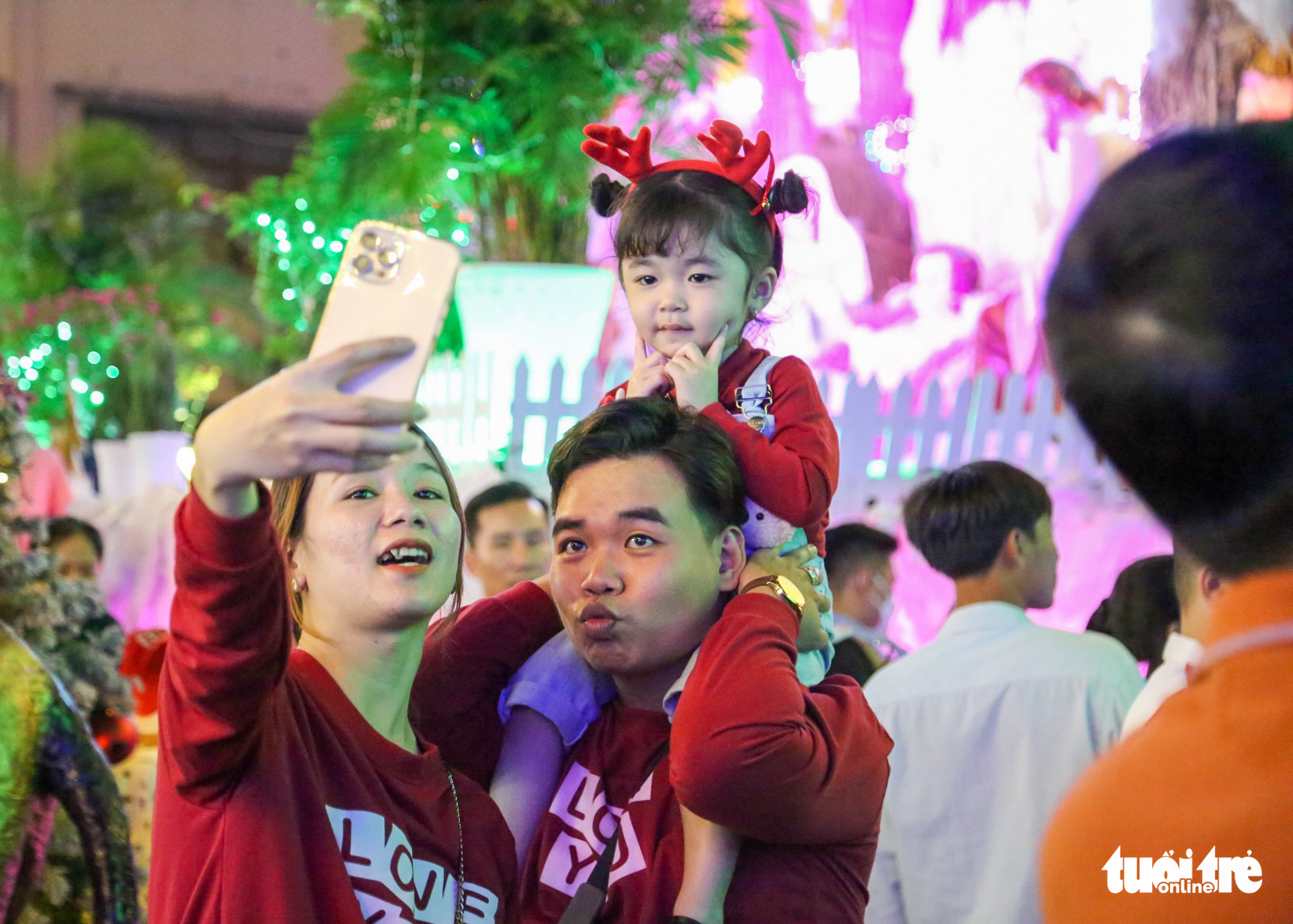 A family takes a photo at Binh An Catholic neighborhood in District 8, Ho Chi Minh City, December 24, 2022. Photo: Phuong Quyen / Tuoi Tre
