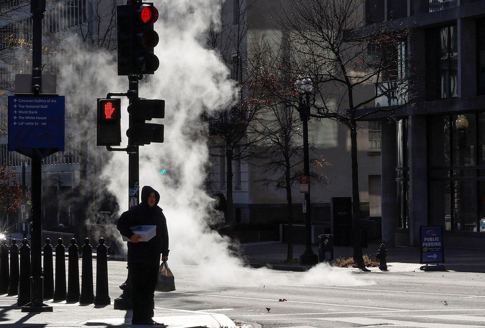 Pedestrians walk in the cold near the White House, as temperatures drop throughout the day as part of a large winter weather system across the country, in Washington, U.S. December 23, 2022. Photo: REUTERS