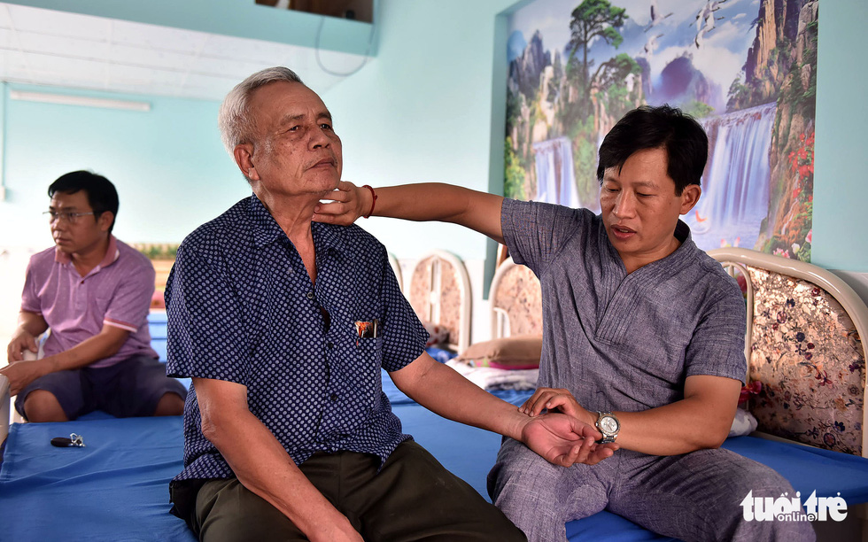 Huy examines patient Vu Xuan Lang in Go Vap District, Ho Chi Minh City.