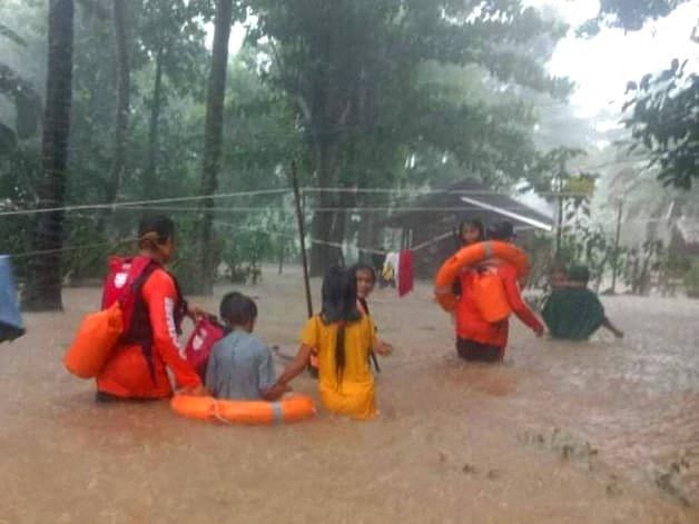 Rescue workers help people affected by floods, in Plaridel, Misamis Occidental Province, Philippines, December 26, 2022. Philippine Coast Guard/Handout via REUTERS