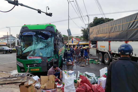 Local residents help to collect passengers’ belongings scattered on the road. Photo: A.B. / Tuoi Tre