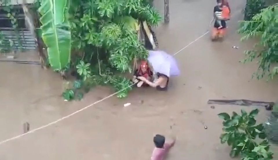 A rescuer helps people affected by floods in Gingoog city, Philippines December 25, 2022 in this screen grab obtained from a social media video. Philippine Red Cross/TWITTER@PHILREDCROSS/via REUTERS