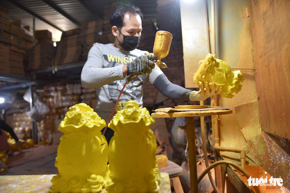 Quoc Lam is coating lucky money bags with yellow. Photo: Ngoc Phuong / Tuoi Tre