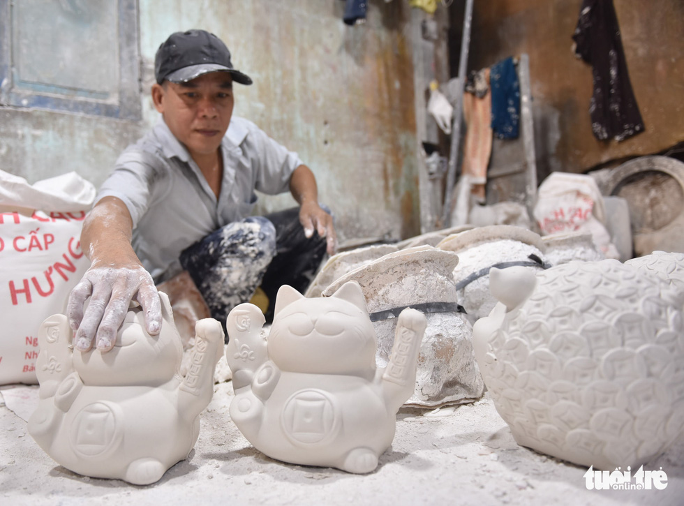 Plaster kitty banks have just been taken out of moulds by Luong Van Hien. Photo: Ngoc Phuong/ Tuoi Tre