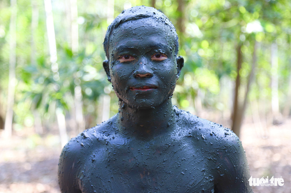 A trainee covered in black mud to camouflage himself. Photo: Danh Trong / Tuoi Tre