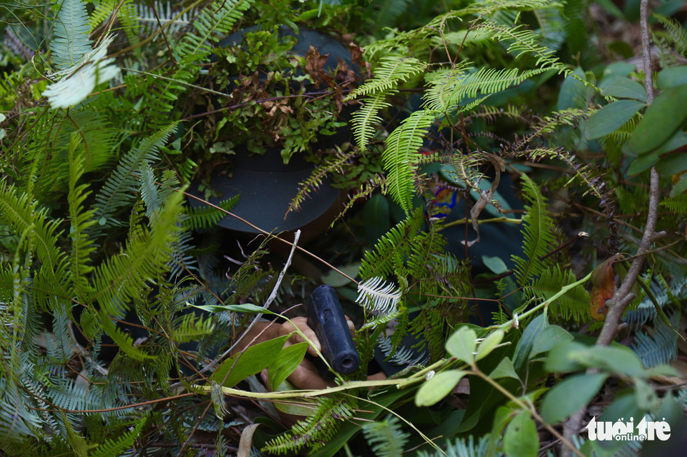 First-class private Tran Manh Luan camouflages himself with forest greenery. Photo: Danh Trong / Tuoi Tre