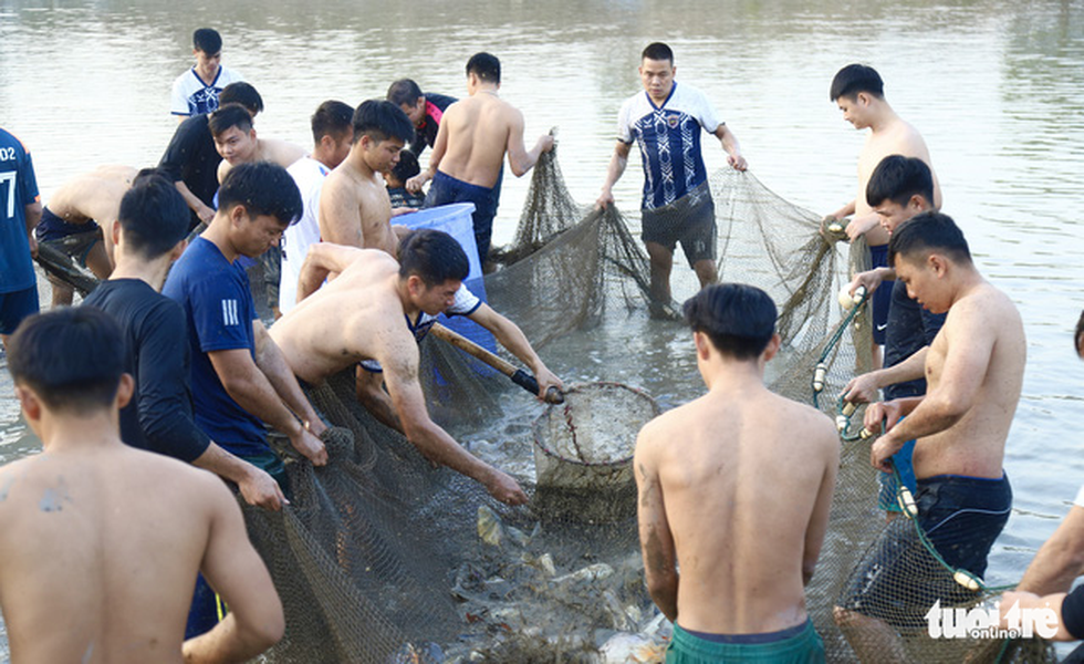 Mobile police officers catch fish during a training session. Photo: Danh Trong / Tuoi Tre