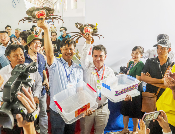 Winning racer crabs are lifted by their owners following the race. Photo: Quoc Rin