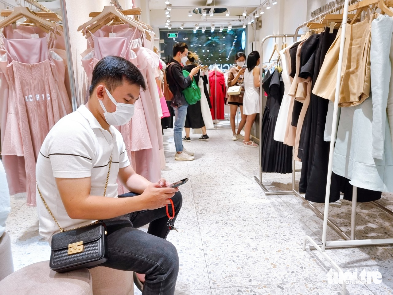 A man waits for his girlfriend during a clothes shopping on Nguyen Trai Street in District 1, Ho Chi Minh City, January 2023. Photo: Nhat Xuan / Tuoi Tre