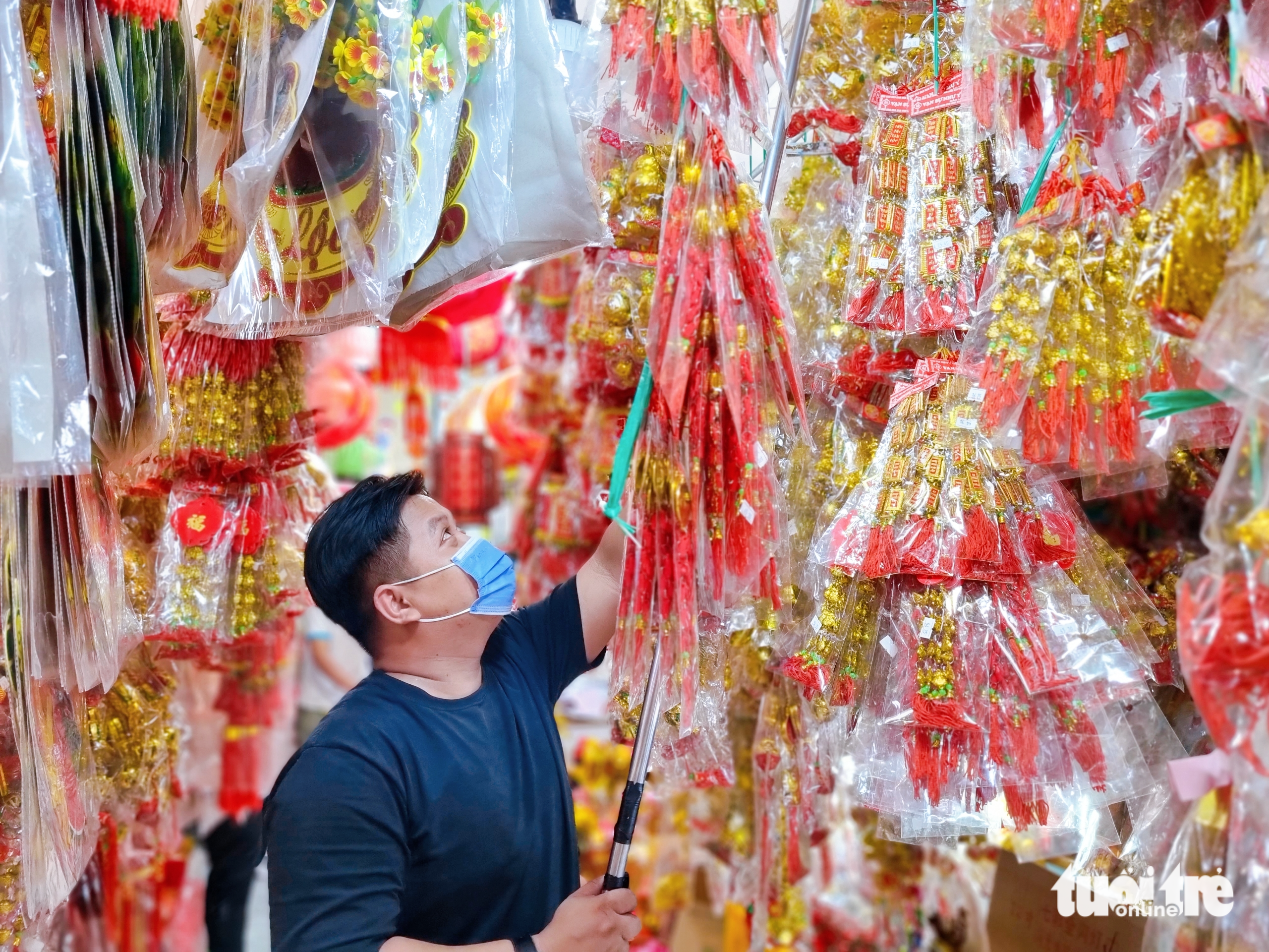 A man displays Tet decorations at a store on Hai Thuong Lan Ong Street in District 5, Ho Chi Minh City. Photo: Nhat Xuan / Tuoi Tre