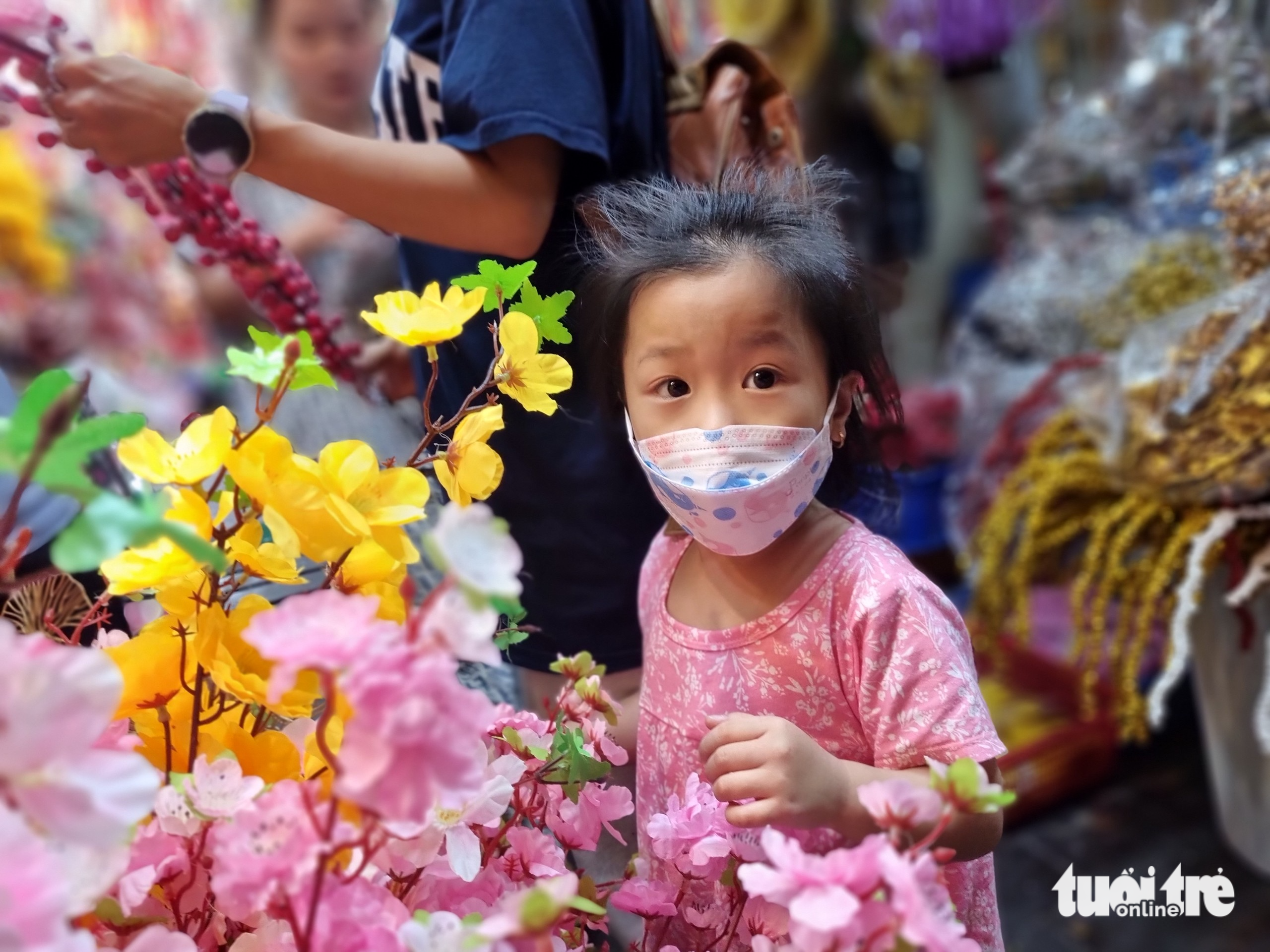 A girl goes shopping for Tet decorations with her parents at a store on Hai Thuong Lan Ong Street in District 5, Ho Chi Minh City. Photo: Nhat Xuan / Tuoi Tre