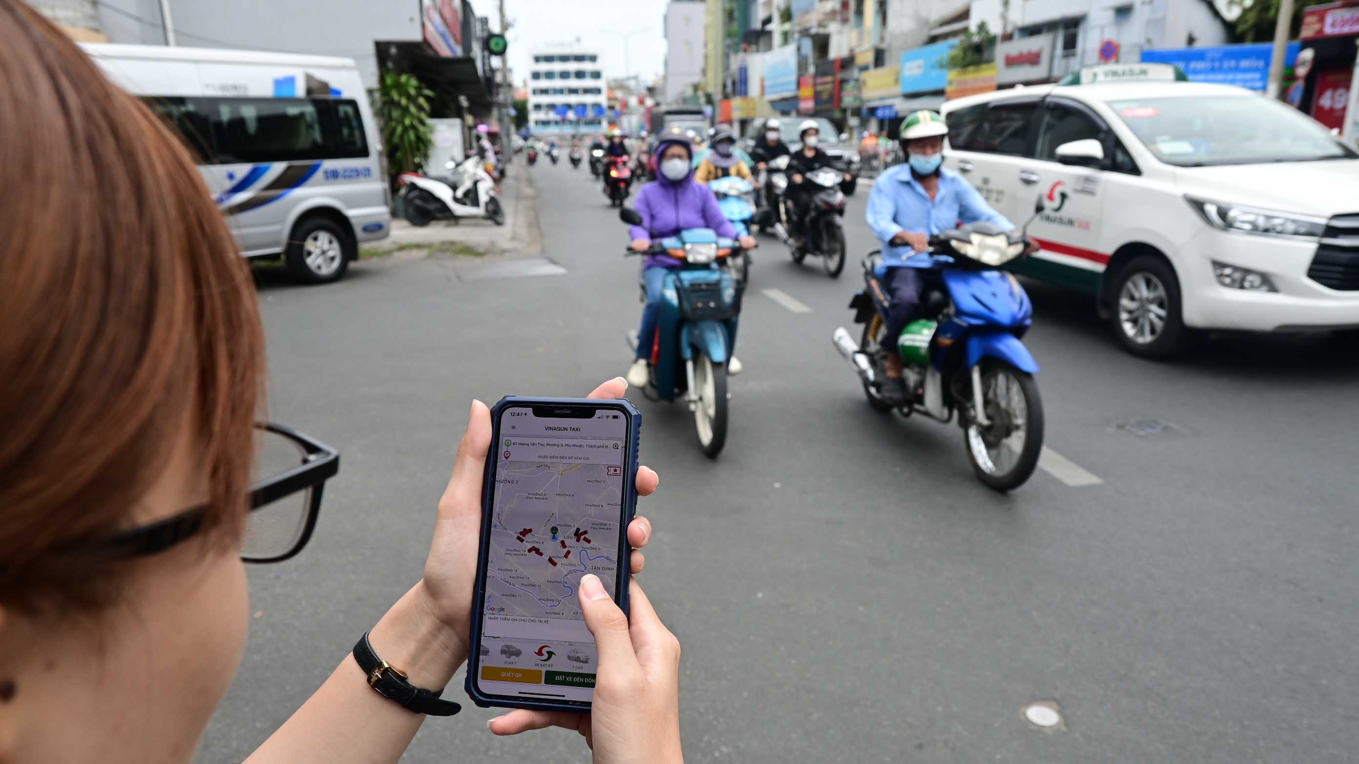 A resident booked a taxi through an app in Phu Nhuan District, Ho Chi Minh City on January 5, 2023. Photo: Quang Dinh / Tuoi Tre