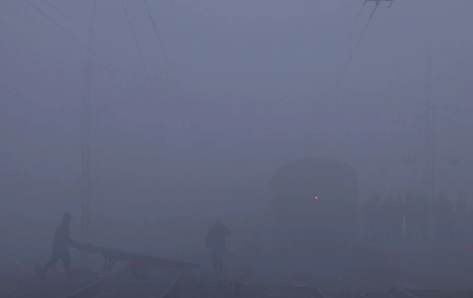 A labourer pushes a cart as he crosses railway tracks amidst heavy fog on a cold winter morning in New Delhi, India, January 9, 2023. Photo: Reuters