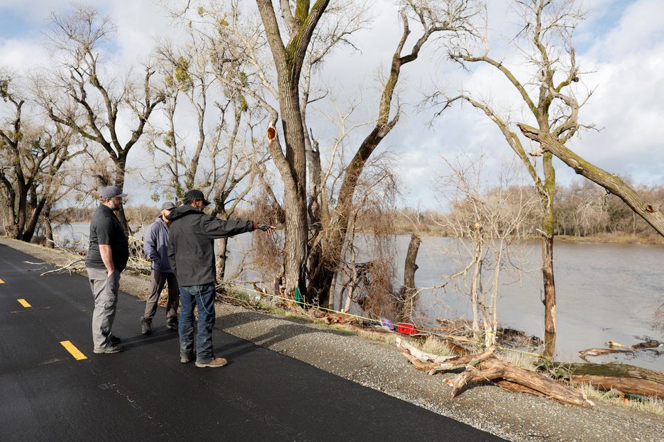 Joe Costa, a friend of a homeless woman who was killed by a falling tree branch during the storm, speaks with county outreach workers at the site of the accident, at the bank of the Sacramento River, in Sacramento, California, U.S. January 8, 2023. REUTERS/Fred Greaves