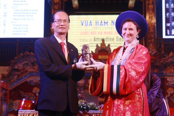 Amandine Dabat (R), the fifth generation descendant of Emperor Ham Nghi, hands over a wooden pipe that was used by Emperor Ham Nghi to a representative of the Hue Monuments Conservation Center in Thua Thien-Hue Province, Vietnam, January 10, 2023. Photo: Nhat Linh / Tuoi Tre