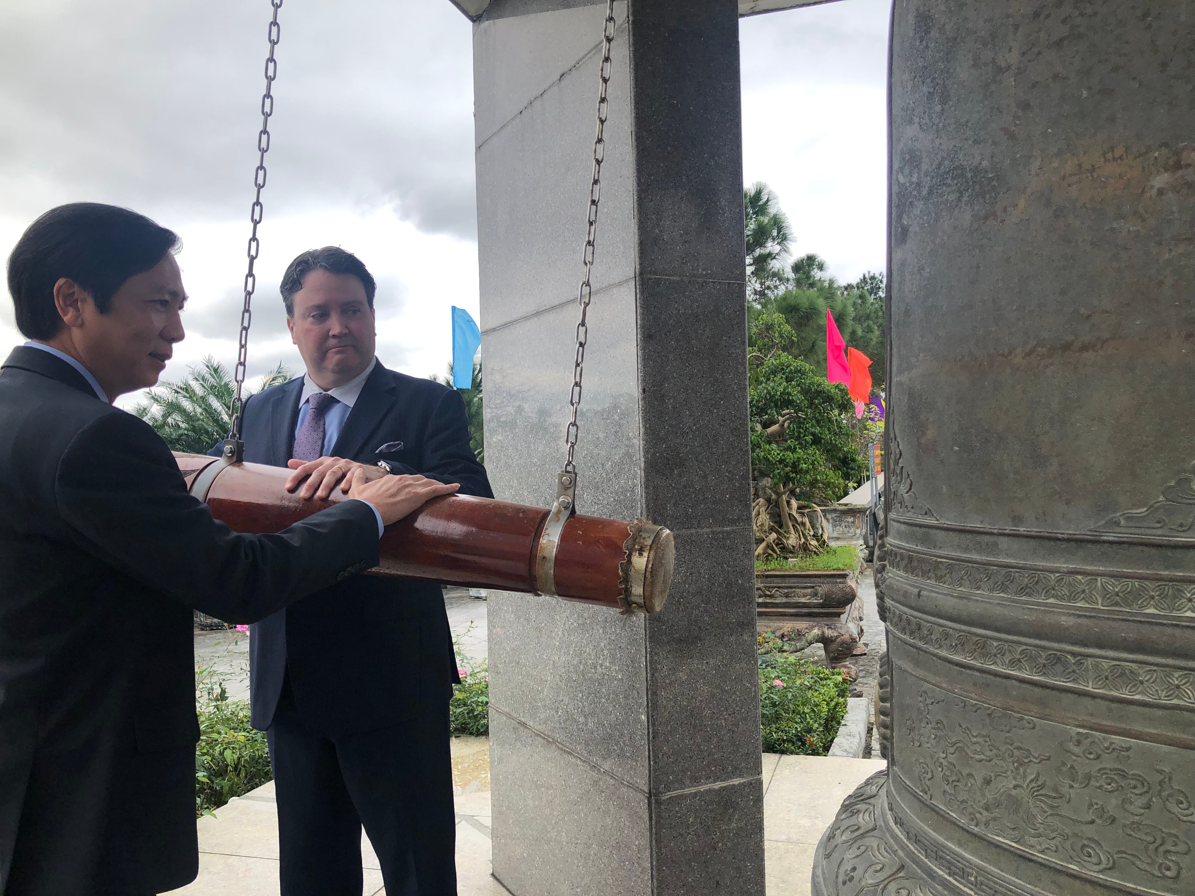 U.S. Ambassador to Vietnam Marc Knapper (R) and vice-chairman of the Quang Tri People’s Committee Hoang Nam ring the bell at the Road 9 National Martyrs' Cemetery, January 11, 2022. Photo: Hong Van / Tuoi Tre