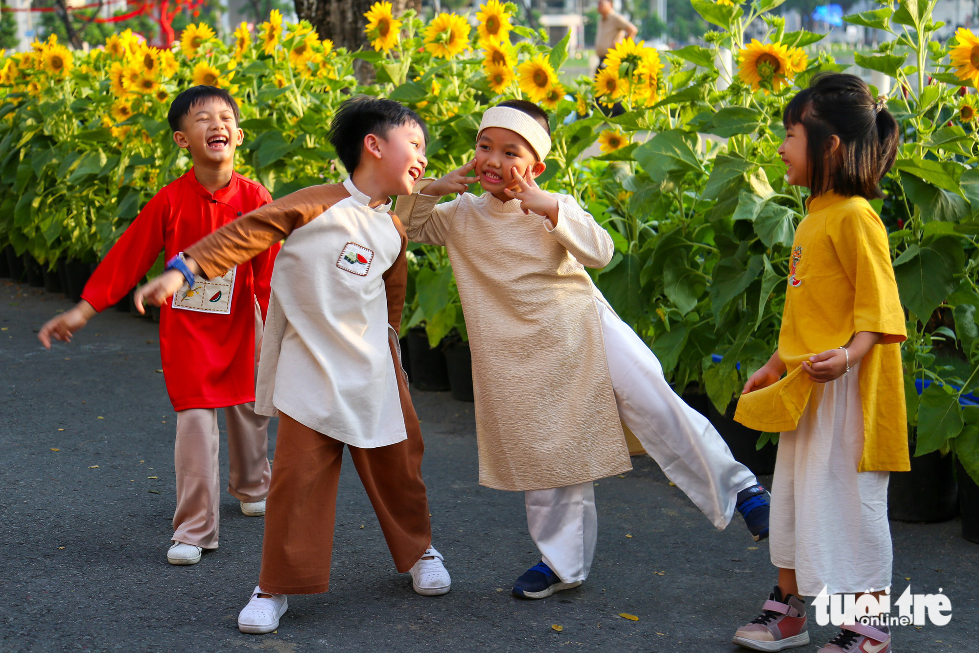 Tom (in creamy ao dai, a Vietnamese traditional costume) and his friends are taken to the flower festival by their parents so that they can have Tet memories in their childhood. Photo: Phuong Quyen / Tuoi Tre