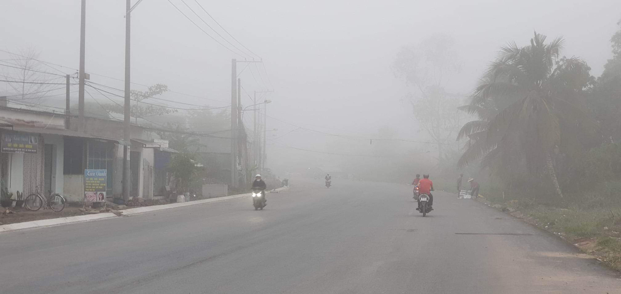 People travel in foggy weather along a street in Can Tho City, Vietnam, January 16, 2022. Photo: Le Dan / Tuoi Tre