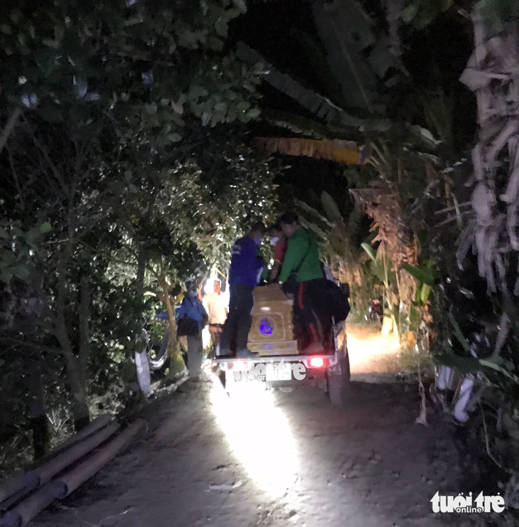 Rescuers take the body of the boy to his house on early Friday morning. Photo: Dang Tuyet / Tuoi Tre