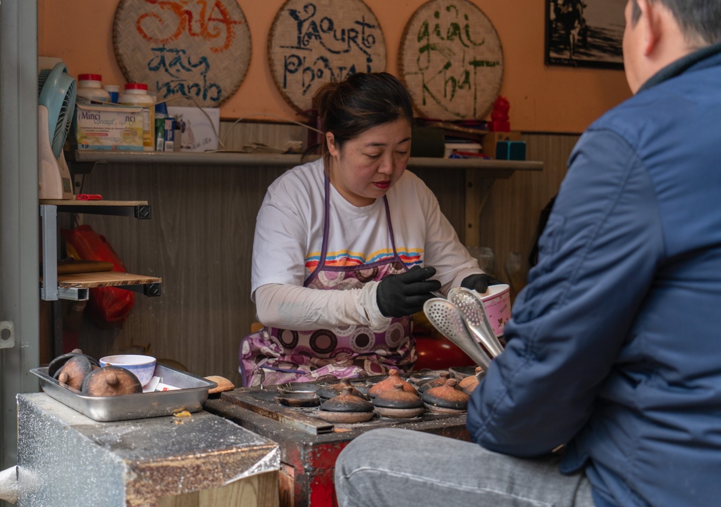 A woman puts rice flour into ceramic molds to make banh can. Photo: Nguyen Trung Au / Tuoi Tre News