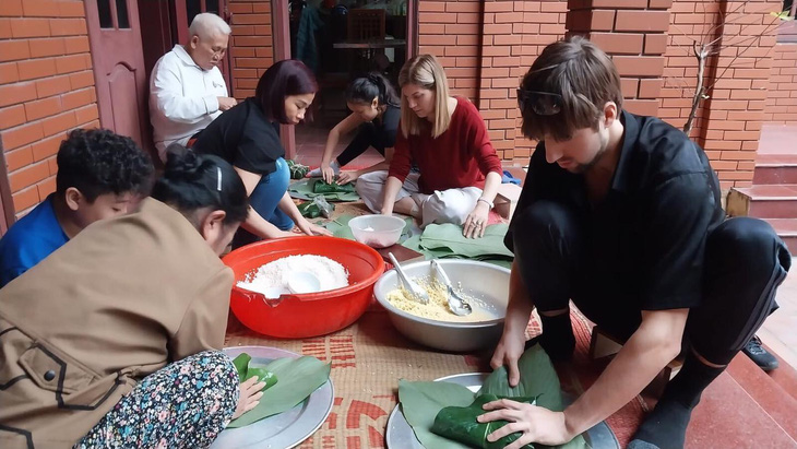 Officers of the Embassy of Canada in Vietnam make banh chung with Vietnamese people. Photo: Embassy of Canada in Vietnam