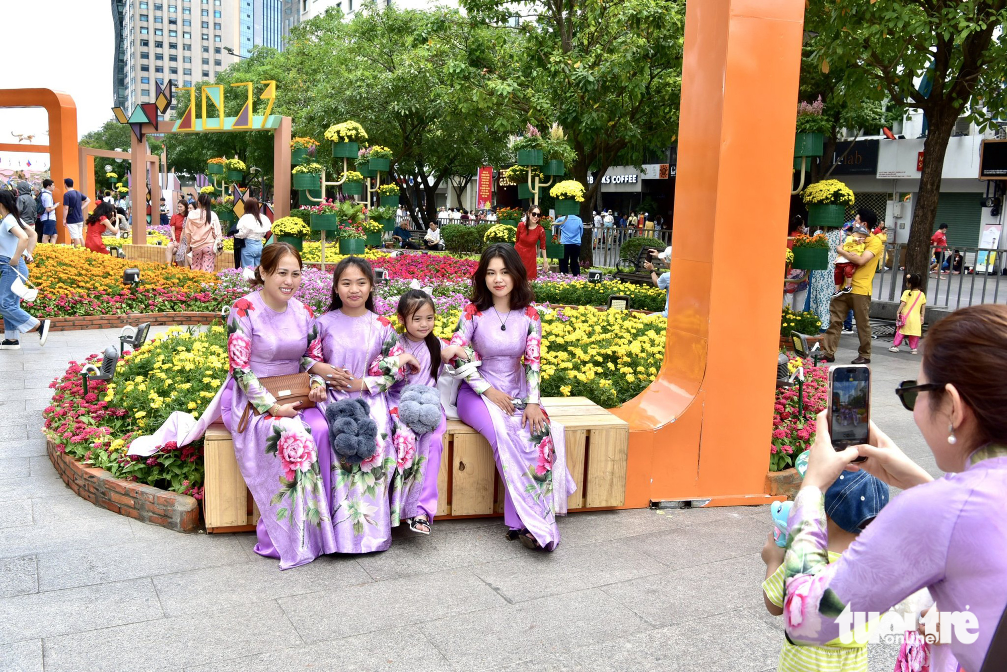 This image shows four members of the family of Ly Nguyen, a woman in Ho Chi Minh City, posing for a photo at the Nguyen Hue Flower Street in District 1, Ho Chi Minh City, on January 22, 2023 – the first day of the Lunar New Year.  Photo: T.T.D. / Tuoi Tre