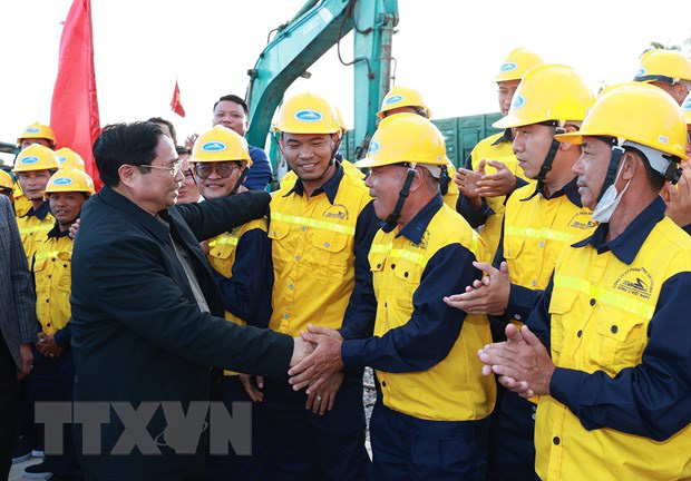 Prime Minister Pham Minh Chinh (L) is seen shaking hands with railway engineers and workers at the Thap Cham railway station in Ninh Thuan Province, south-central Vietnam on January 26, 2023. Photo: Vietnam News Agency