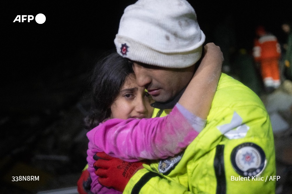 Police officer Zekeriya Yildiz hugs his daughter after they saved her from the rubble in Hatay, southwest Turkey on February 6, 2023. Photo: AFP