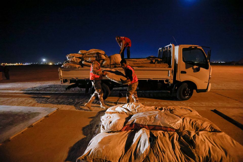 Iraqi soldiers and Iraqi Red Crescent society workers unload trucks with aid that will be shipped on a plane of emergency relief to Syria to support victims of the deadly earthquake, at a military airbase near Baghdad International Airport in Baghdad, Iraq, February 6, 2023. Photo: Reuters