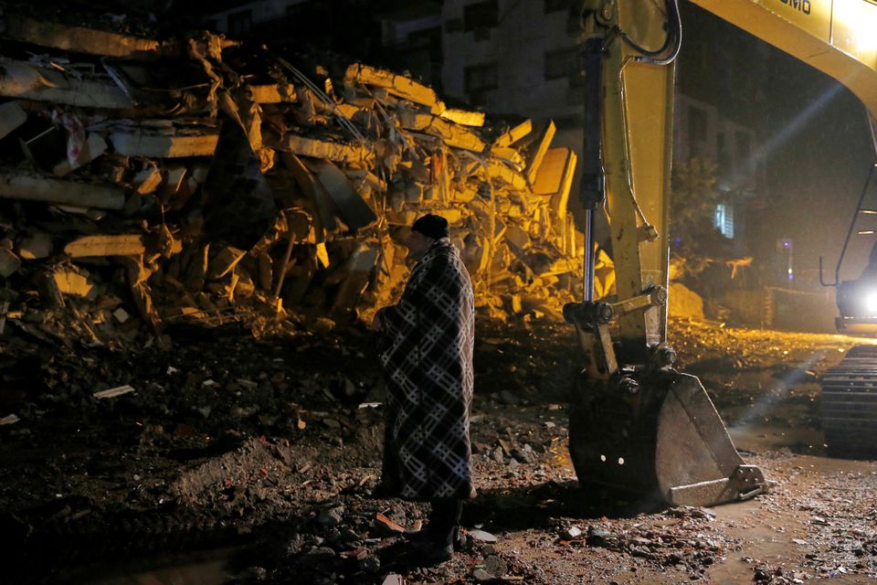 A man stands in front of a collapsed building after an earthquake in Osmaniye, Turkey February 6, 2023. Photo: Reuters