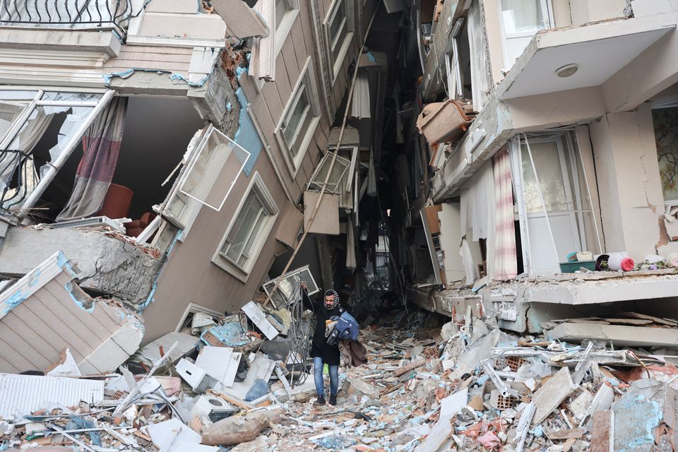 A survivor walks carrying belongings salvaged from his destroyed home, in the aftermath of a deadly earthquake in Hatay, Turkey February 9, 2023. Photo: Reuters