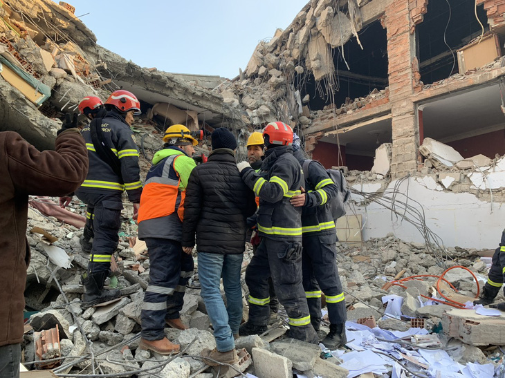 Vietnamese rescuers are seen consulting their foreign colleagues while working in an area of quake-destroyed buildings in the southeastern Turkish city of Adiyaman on February 11, 2023. Photo: Vietnamese rescue team
