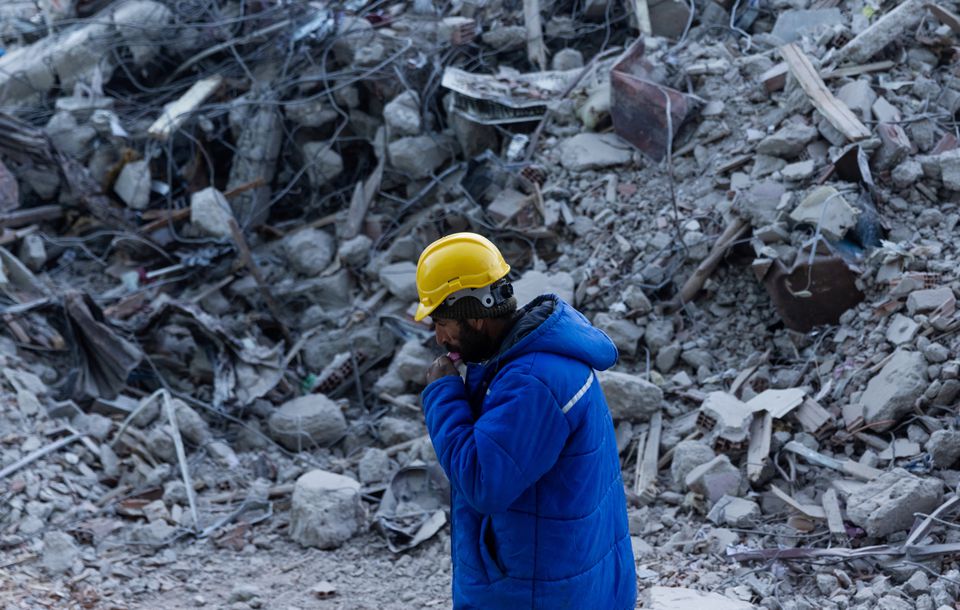 A man walks next to a destroyed building in the aftermath of a deadly earthquake in Elbistan, Turkey February 14, 2023. Photo: Reuters